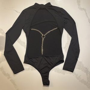 Black body suit with gold accent chain on back